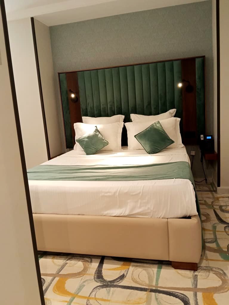 Tête de lit en velours vert d'une chambre double de l'Hôtel Printania