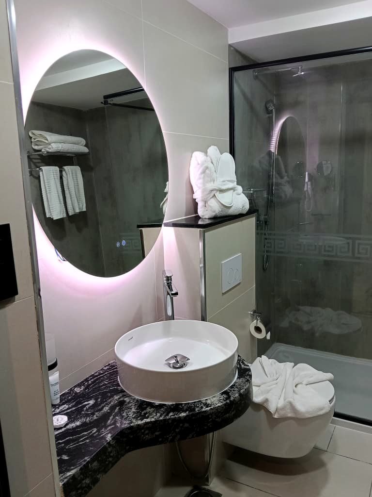 Miroir LED et vasque d'une salle de bain de l'Hôtel Printania