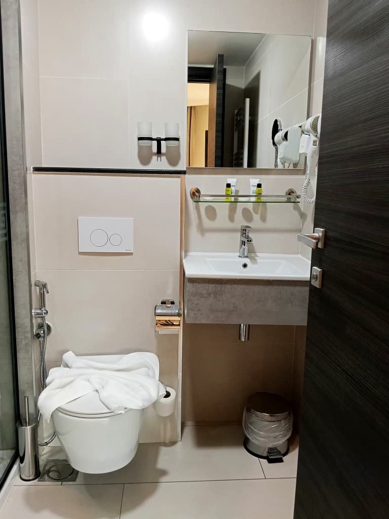 Vasque et produits d'accueil dans une salle de bain de l'Hôtel Printania